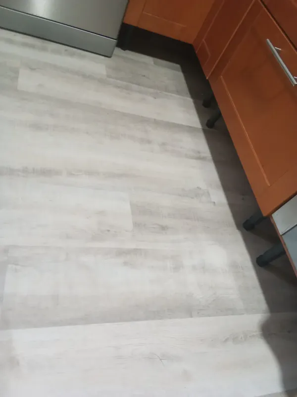 instalación de suelo laminado vivienda en Ripollet - detalle de acabado mostrando proceso de trabajo